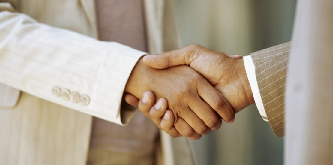 close-up of a businessman shaking hands with a businesswoman --- Image by © Royalty-Free/Corbis